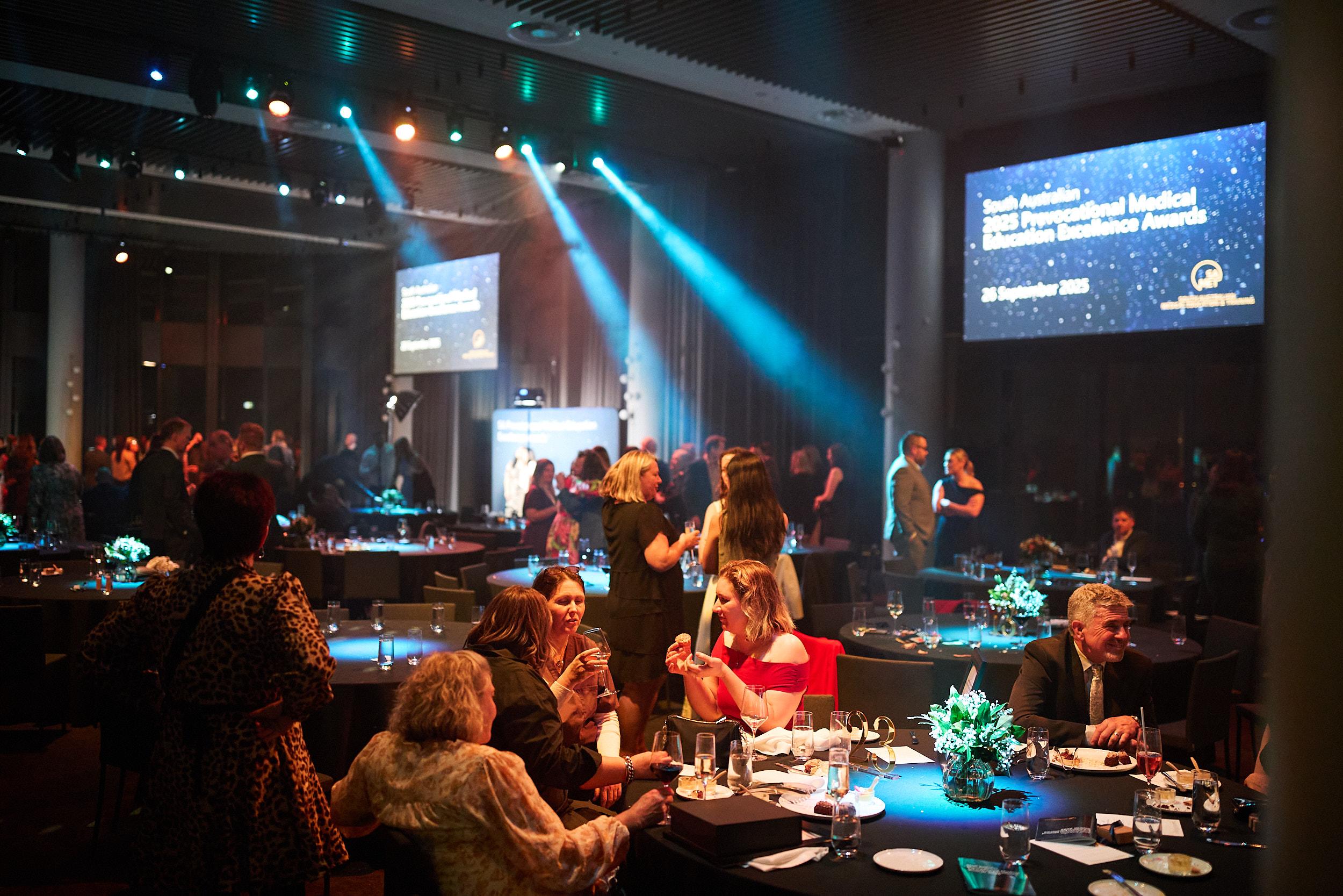 2025 Prevocational Medical Education Awards, image of ball room with people standing and networking 